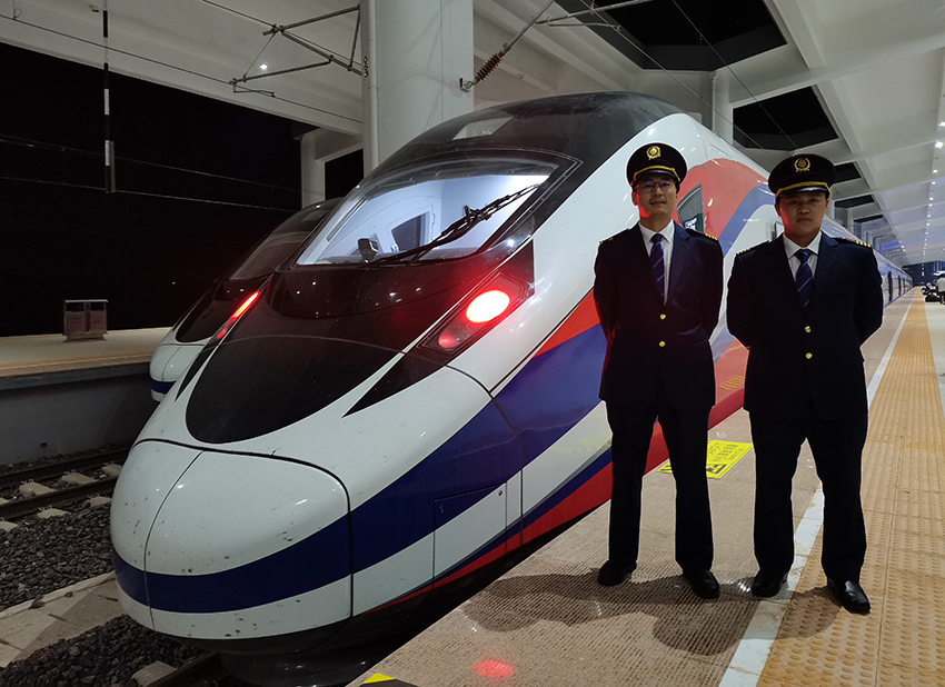 劉銀能（右一）與中國師父鄔俊鴻在動(dòng)車組前合影。受訪者供圖